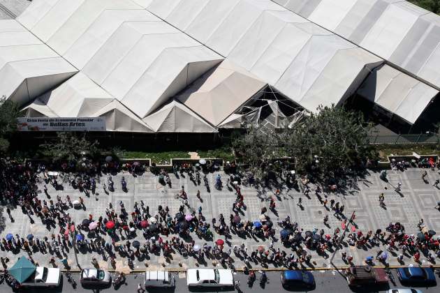 People queue to buy goods in a Mega-Mercal, a subsidized state-run street market, in Caracas