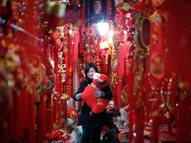 A woman looks at a toy sheep at a shop in downtown Shanghai