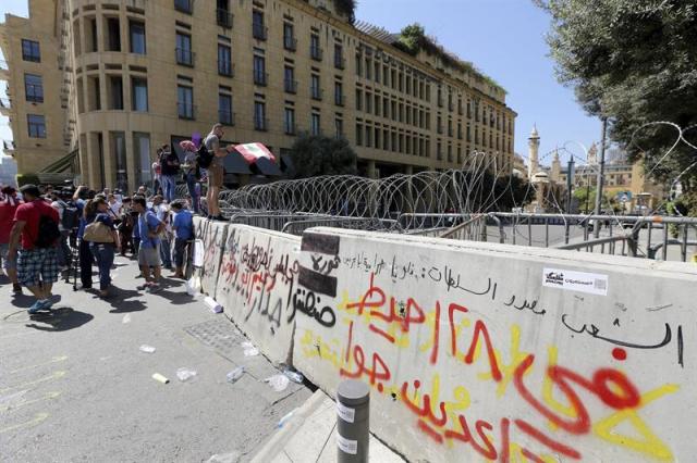 Manifestantes protestan junto a unas barreras que protegen el Parlamento en Beirut (Líbano) hoy, 22 de septiembre de 2015. EFE/Nabil Mounzer