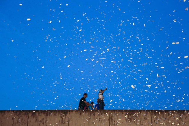 Supporters of the opposition Democratic Unity coalition stand on the roof of a building as they participate in a concert to celebrate their victory in the election last Sunday, in Caracas, December 13, 2015. REUTERS/Marco Bello FOR EDITORIAL USE ONLY. NO RESALES. NO ARCHIVE.      TPX IMAGES OF THE DAY