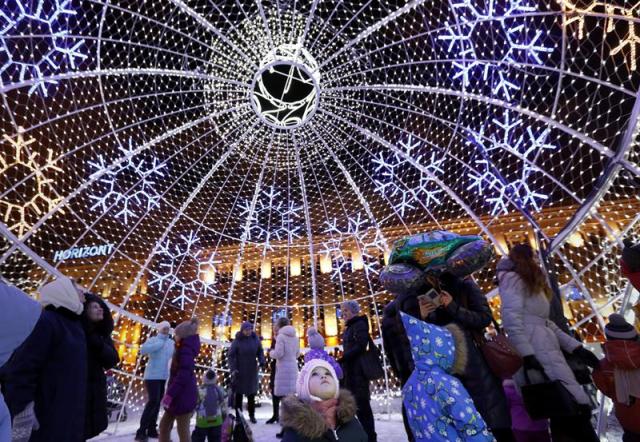 Varias personas caminan dentro de una gran bola decorativa de Navidad en la plaza Octyabrskaya durante las fiestas de Navidad y de Año Nuevo en Minsk (Bielorrusia) ayer, 29 de diciembre de 2015. EFE/Tatyana Zenkovich