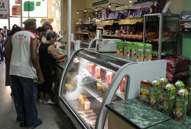 People buy groceries at a store in Havana, on April 22, 2016.  Cuba announced a reduction of up to 20% in the controlled prices of some foods, which takes effect Friday to raise the purchasing power of the exiguous wages.  / AFP PHOTO / JORGE BELTRAN
