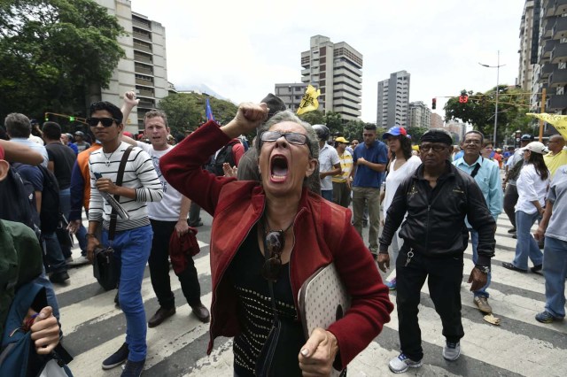 Demonstrators protest against new emergency powers decreed this week by President Nicolas Maduro in Caracas on May 18, 2016. Public outrage was expected to spill onto the streets of Venezuela Wednesday, with planned nationwide protests marking a new low point in Maduro's unpopular rule. / AFP PHOTO / JUAN BARRETO