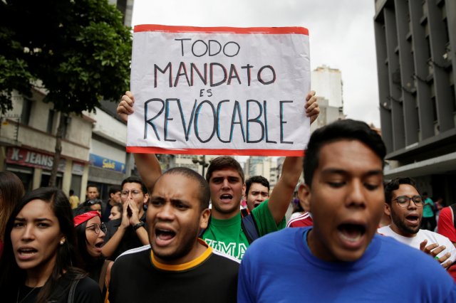 A student demonstrator holds a sign that reads "All mandates are revocable" during a gathering to protest against Venezuelan President Nicolas Maduro's government in Caracas, Venezuela August 24, 2016. REUTERS/Marco Bello