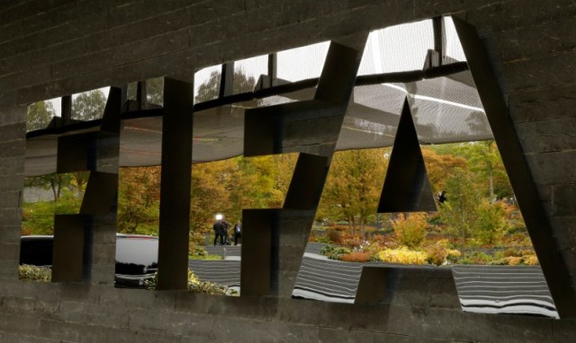 En esta imagen de archivo, un equipo de TV aparece reflejado en un logo de la FIFA en su sede de Zurich, el 13 de octubre de 2016. La FIFA decidió sancionar a las asociaciones de fútbol de Chile y Honduras con la suspensión de sus principales estadios para la eliminatoria al Mundial, y multó a Argentina, Colombia, Panamá, México y Venezuela por cánticos homofóbicos de sus hinchas, dijo el lunes la entidad.  REUTERS/Arnd Wiegmann