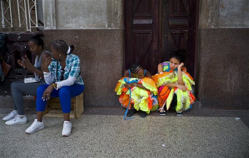 En esta fotografía del martes 10 de enero de 2017, bailarinas con sus atavíos aguardan la llegada del cantante Enrique Iglesias cerca de un lugar donde el artista iba a filmar un video musical en La Habana Vieja, en Cuba. Las imágenes del video son para un sencillo de Enrique Iglesias que saldrá a la venta este año. (AP Foto/Ramón Espinosa)