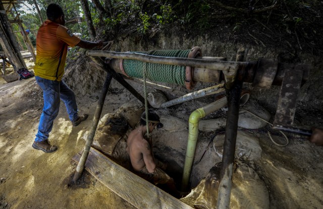 Ender Moreno descends into La Culebra underground gold mine in El Callao, Bolivar state, southeastern Venezuela on March 1, 2017. Although life in the mines of eastern Venezuela is hard and dangerous, tens of thousands from all over the country head for the mines daily in overcrowded trucks, pushed by the rise in gold prices and by the severe economic crisis affecting the country, aggravated recently by the drop in oil prices. / AFP PHOTO / JUAN BARRETO