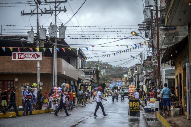 View of a sign reading "We buy gold" in a street of El Callao, Bolivar state, southeastern Venezuela on February 25, 2017. Although life in the mines of eastern Venezuela is hard and dangerous, tens of thousands from all over the country head for the mines daily in overcrowded trucks, pushed by the rise in gold prices and by the severe economic crisis affecting the country, aggravated recently by the drop in oil prices. / AFP PHOTO / JUAN BARRETO