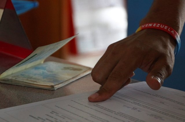 Un ciudadano venezolano estampa su huella digital en los documentos para obtener su Permiso Temporal de Permanencia, la visa que habilitó el gobierno peruano para permitir a miles de venezolanos resolver su situación migratoria en el país. Credit Guadalupe Pardo/Reuters