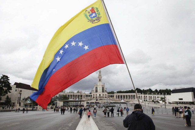 PAC01 FÁTIMA (PORTUGAL), 10/05/2017.- Un peregrino ondea la bandera venezolana en el santuario de Fátima, Portugal, hoy, 10 de mayo de 2017. El papa Francisco afirmó hoy durante la audiencia que en su visita los próximo viernes y sábado al santuario de Fátima pondrá en manos de la Virgen "el destino temporal y eterno de la humanidad". EFE/Paulo Cunha