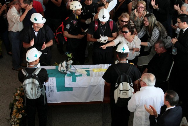 Volunteers, members of a primary care response team and mourners stand next to the coffin of their fellow team mate Paul Moreno, who died while on duty during a protest against Venezuelan President Nicolas Maduro’s government in Maracaibo, Venezuela, May 19, 2017. REUTERS/Isaac Urrutia