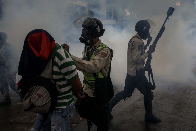 CAR101. CARACAS (VENEZUELA), 29/06/2017.- Agentes detienen a manifestantes durante una marcha hacia la sede del Poder Electoral hoy, jueves 29 de junio de 2017, en Caracas (Venezuela). Venezuela vive desde hace 90 días una ola de manifestaciones a favor y en contra del Gobierno, algunas de las cuales han desencadenado hechos violentos que se saldan con al menos 79 fallecidos, según la Fiscalía. EFE/Miguel Gutiérrez