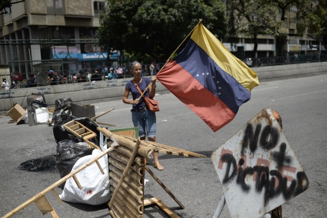 Venezuelan opposition activists protest in Caracas on July 10, 2017. Venezuela hit its 100th day of anti-government protests Sunday, amid uncertainty over whether the release from prison a day earlier of prominent political prisoner Leopoldo Lopez might open the way to negotiations to defuse the profound crisis gripping the country. / AFP PHOTO / FEDERICO PARRA