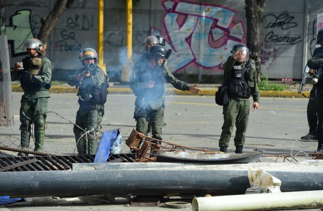 Opposition demonstrators and riot police clash during an anti-government protest in Caracas, on July 20, 2017. A 24-hour nationwide strike got underway in Venezuela Thursday, in a bid by the opposition to increase pressure on beleaguered leftist President Nicolas Maduro following four months of deadly street demonstrations. / AFP PHOTO / RONALDO SCHEMIDT