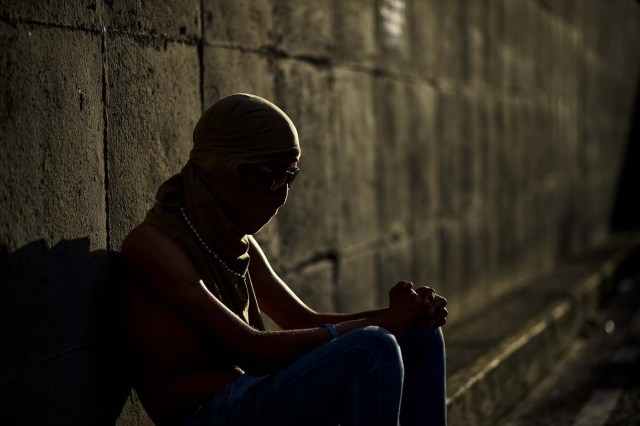 An opposition demonstrator is pictured next to the site where young activist Neomar Lander was mortally wounded during clashes with riot police, during a protest in Caracas, on July 24, 2017 Venezuela's angry opposition is pushing for a boycott of an upcoming vote that it dismisses as a ploy by President Nicolas Maduro to cling to power. / AFP PHOTO / RONALDO SCHEMIDT