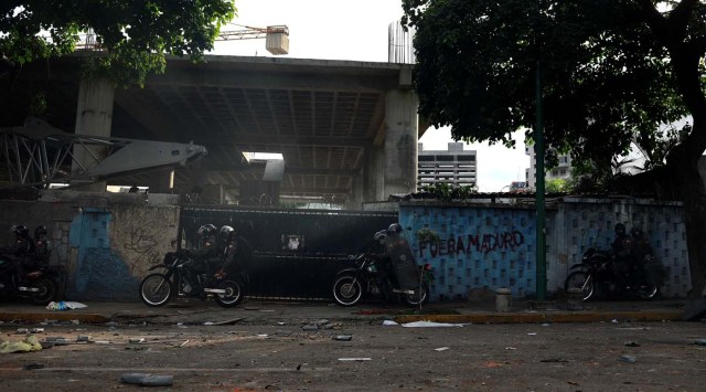 Riot security forces motorcyclists ride past a graffiti that reads "Maduro out" at a rally during a strike called to protest against Venezuelan President Nicolas Maduro's government in Caracas, Venezuela July 27, 2017. REUTERS/Marco Bello
