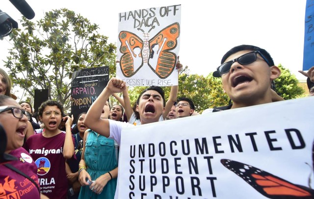 Young immigrants and supporters walk holding signs during a rally in support of Deferred Action for Childhood Arrivals (DACA) in Los Angeles, California on September 1, 2017. A decision is expected in coming days on whether US President Trump will end the program by his predecessor, former President Obama, on DACA which has protected some 800,000 undocumented immigrants, also known as Dreamers, since 2012. / AFP PHOTO / FREDERIC J. BROWN