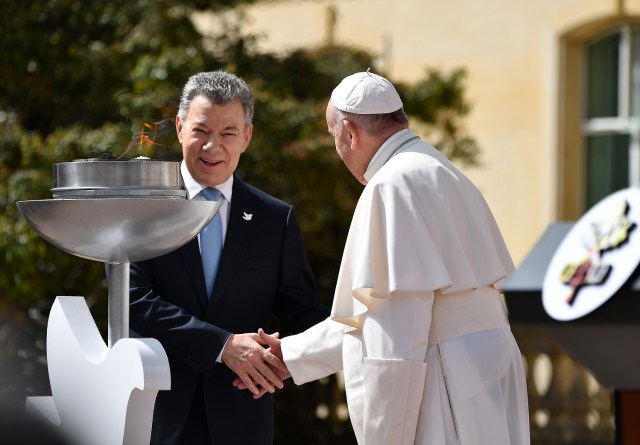 Colombian President Juan Manuel Santos (L) and Pope Francis shake hands during a ceremony at the Nariño presidential palace in Bogota on September 7, 2017. Pope Francis holds an open-air mass Thursday in Colombia and meets with its Nobel Peace Prize-winning president to cheer the country on its march towards reconciliation after a half-century war. / AFP PHOTO / Alberto PIZZOLI