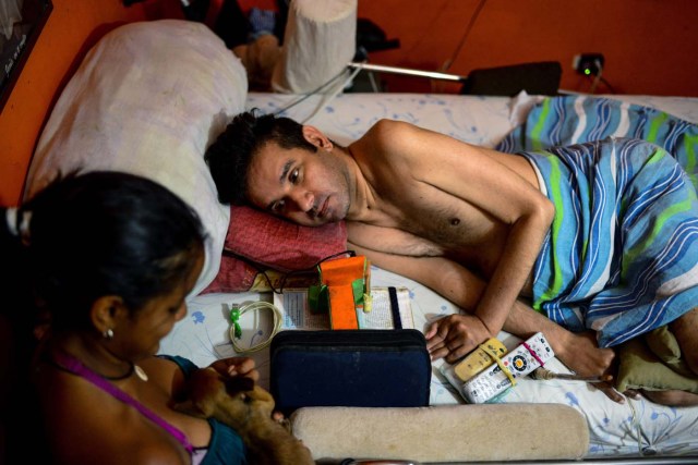 Marco Guillen (R), a 45-year-old quadriplegic, talks with his daughter Daikellys Mosquera at his house in Barquisimeto, Lara state, Venezuela on October 23, 2017. Marco Guillen became quadriplegic in an accident twelve years ago, amid Venezuela's deep economical crisis he desperately asks President Maduro's government to help him to live with dignity, meeting his medical necessities otherwise he pleads for euthanasia. / AFP PHOTO / FEDERICO PARRA / TO GO WITH AFP STORY by MARGIONI BERMUDEZ