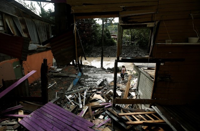 A woman walks near a house damaged by a mudslide after Storm Nate in the outskirts of San Jose, Costa Rica October 6, 2017. REUTERS/Juan Carlos Ulate