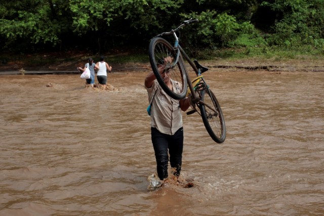 A local resident cross a river flooded by heavy rains by Tropical Storm Nate in Nandaime town, Nicaragua October 6, 2017. REUTERS/Oswaldo Rivas