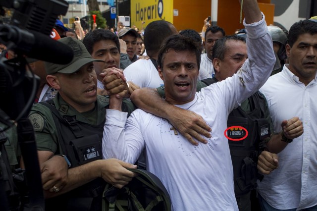 CAR51. CARACAS (VENEZUELA), 18/02/2014.- El dirigente opositor venezolano Leopoldo López se entrega a miembros de la Guardia Nacional (GNB, policía militarizada) hoy, martes 18 de febrero de 2014, en una plaza en Caracas (Venezuela). López, contra el que pesa una orden de captura por los incidentes del pasado miércoles al término de una marcha que dejaron tres muertos, fue introducido en un vehículo blindado de la GNB que salió entre cientos de seguidores de López, según pudo constatar Efe. EFE/Miguel Gutiérrez