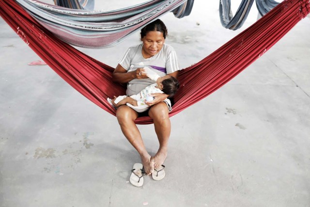 An indigenous Warao woman from the Orinoco Delta in eastern Venezuela, bottle-feeds her baby at a shelter in Pacaraima, Roraima state, Brazil November 15, 2017. Picture taken November 15, 2017. REUTERS/Nacho Doce