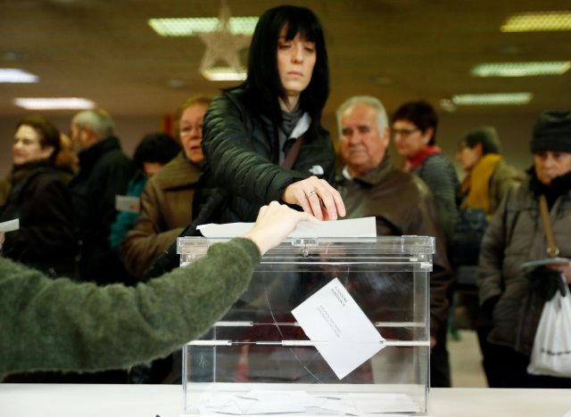 A woman casts her ballot as others wait to vote in Catalonia's regional elections at a polling station in Vic, Spain December 21, 2017. REUTERS/Juan Medina