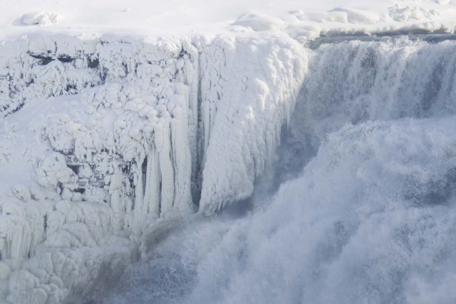 Ice hangs from the top of the American side of Niagara Falls on January 3, 2018.  The cold snap which has gripped much of Canada and the United States has nearly frozen over the American side of the falls. / AFP PHOTO / Geoff Robins