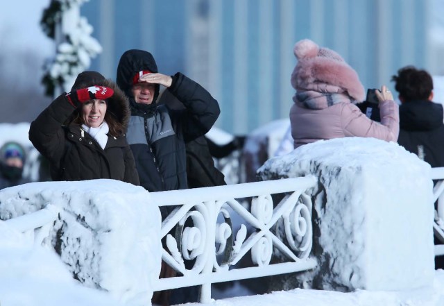 Visitors watch the ice covered Horseshoe Falls in Niagara Falls, Ontario, Canada, January 3, 2018. REUTERS/Aaron Lynett