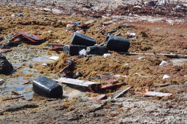 ATTENTION EDITORS - VISUALS COVERAGE OF SCENES OF INJURY OR DEATH Human bodies, plastic containers and pieces of wood are seen at the shore, after a boat broke apart, according to a Venezuelan relative of one of the passengers on board who survived, near Willemstad, Curacao January 10, 2018. Picture taken January 10, 2018. REUTERS/Umpi Welvaart TEMPLATE OUT