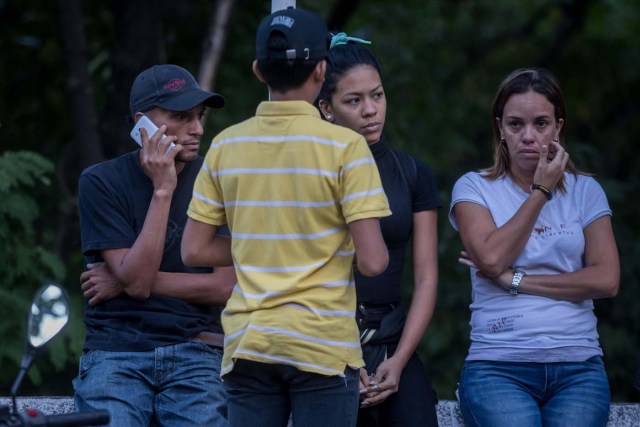 CAR001. CARACAS (VENEZUELA), 18/01/2018. Luis Bolívar (i) y Nicol Díaz (c), el primo hermano y la hija de José Alejandro Díaz Pimentel, respectivamente, quien era funcionario de la Contrainteligencia Militar y se unió a la rebelión de Pérez, permanece en las inmediaciones de la morgue hoy, jueves 18 de enero del 2018, en Caracas (Venezuela). Parlamentarios de la oposición venezolana denunciaron hoy que las autoridades han presionado a familiares del inspector de Policía Óscar Pérez y de los otros seis integrantes del grupo de sublevados que lideraba para que autoricen la cremación de sus cadáveres. EFE/Miguel Gutiérrez