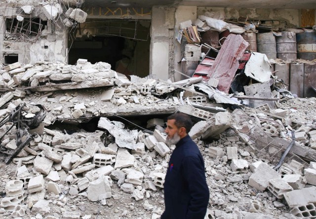 En la imagen, un hombre cerca de un edificio en la localidad sitiada de Guta Oriental, el 25 de febrero de 2018. REUTERS/Bassam Khabieh