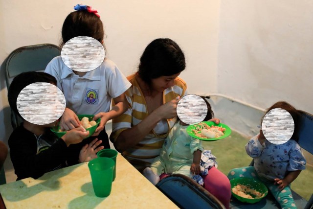 Los hijos de Viviana Colmenares (C) almuerzan en un comedor comunitario en el barrio pobre de Petare en Caracas, Venezuela el 22 de febrero de 2018. Foto tomada el 22 de febrero de 2018. REUTERS / Marco Bello