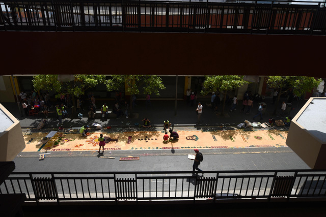 GU4003. CIUDAD DE GUATEMALA (GUATEMALA), 29/03/2018.- Voluntarios guatemaltecos participan en la elaboración de una alfombra de serrín hoy, jueves 29 de marzo de 2018, durante la celebración del Jueves Santo en Ciudad de Guatemala (Guatemala). Miles de guatemaltecos se reunieron este Jueves Santo para elaborar una alfombra de serrín, considerada la más grande del mundo, en el Paseo de la Sexta, la calle peatonal más emblemática del centro histórico de la capital. Los 1.200 voluntarios, convocados por la Municipalidad metropolitana, empezaron hoy a hacer esta alfombra de más de 2.000 metros de longitud y en la que se emplearon un millar de sacos de serrín. EFE/Edwin Bercían