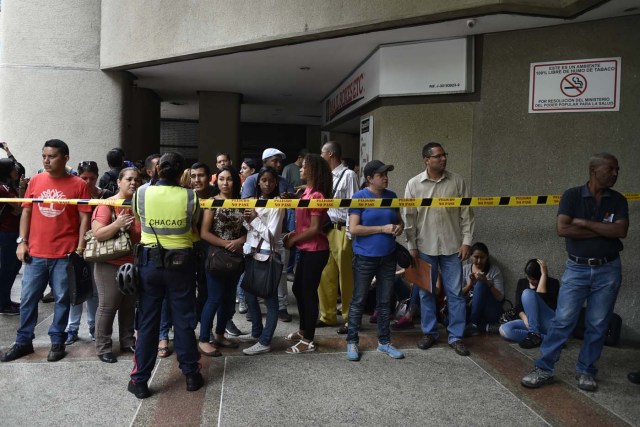 Venezuelans queue at the Chilean consulate in Caracas, to apply for a "Democratic Responsibility Visa" on April 16, 2018. Chilean President Sebastian Pinera announced on April 8 that Chile would ease visa regulations for Venezuelans fleeing the political crisis. In light of the "grave democratic crisis" gripping Venezuela, Pinera said he was creating a so-called visa of "democratic responsibility" which Venezuelan citizens could obtain through the Chilean embassy in Caracas. / AFP PHOTO / Luis ROBAYO
