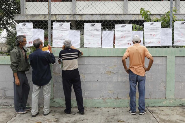 Venezuelan citizens check electoral lists at a polling station during the presidential election in Barquisimeto, Venezuela, May 20, 2018. REUTERS/Carlos Jasso