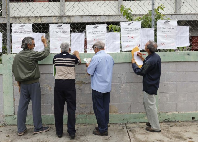Venezuelan citizens check electoral lists at a polling station during the presidential election in Barquisimeto, Venezuela, May 20, 2018. REUTERS/Carlos Jasso