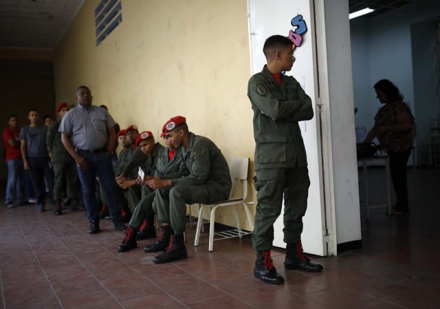 Venezuelan soldiers and civilians wait to cast their votes at a polling station during the presidential election in Caracas, Venezuela, May 20, 2018. REUTERS/Carlos Garcia Rawlins