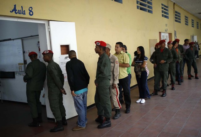 REFILE - CORRECTING TYPO - Venezuelan soldiers and citizens wait to cast their votes at a polling station during the presidential election in Caracas, Venezuela, May 20, 2018. REUTERS/Carlos Garcia Rawlins