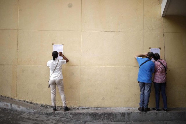 Venezuelan citizens check electoral lists at a polling station during the presidential election in Caracas, Venezuela, May 20, 2018. REUTERS/Carlos Garcia Rawlins