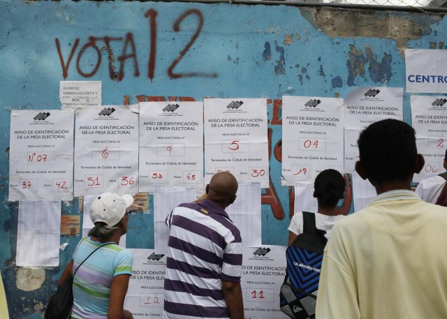 Venezuelan citizens check electoral lists at a polling station during the presidential election in Caracas, Venezuela, May 20, 2018. REUTERS/Adriana Loureiro