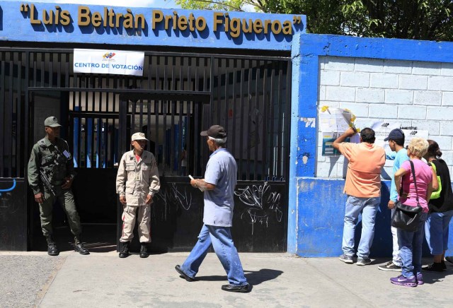 Venezuelan citizens check electoral lists (R) at a polling station during the presidential election in Caracas, Venezuela, May 20, 2018. REUTERS/Marco Bello