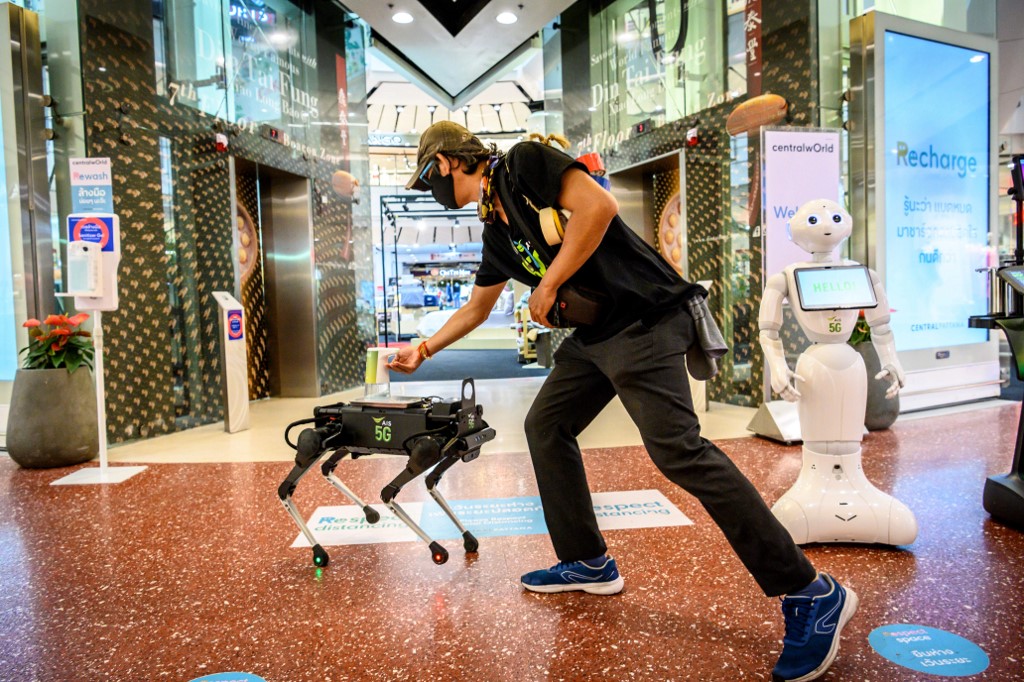 Un perro robot distribuye gel para las manos en un centro comercial en Bangkok