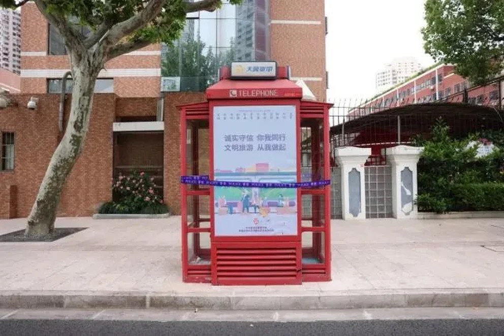 Fue desalojada a la fuerza de una cabina telefónica de Shanghai donde vivió un mes por cuarentena (FOTOS)